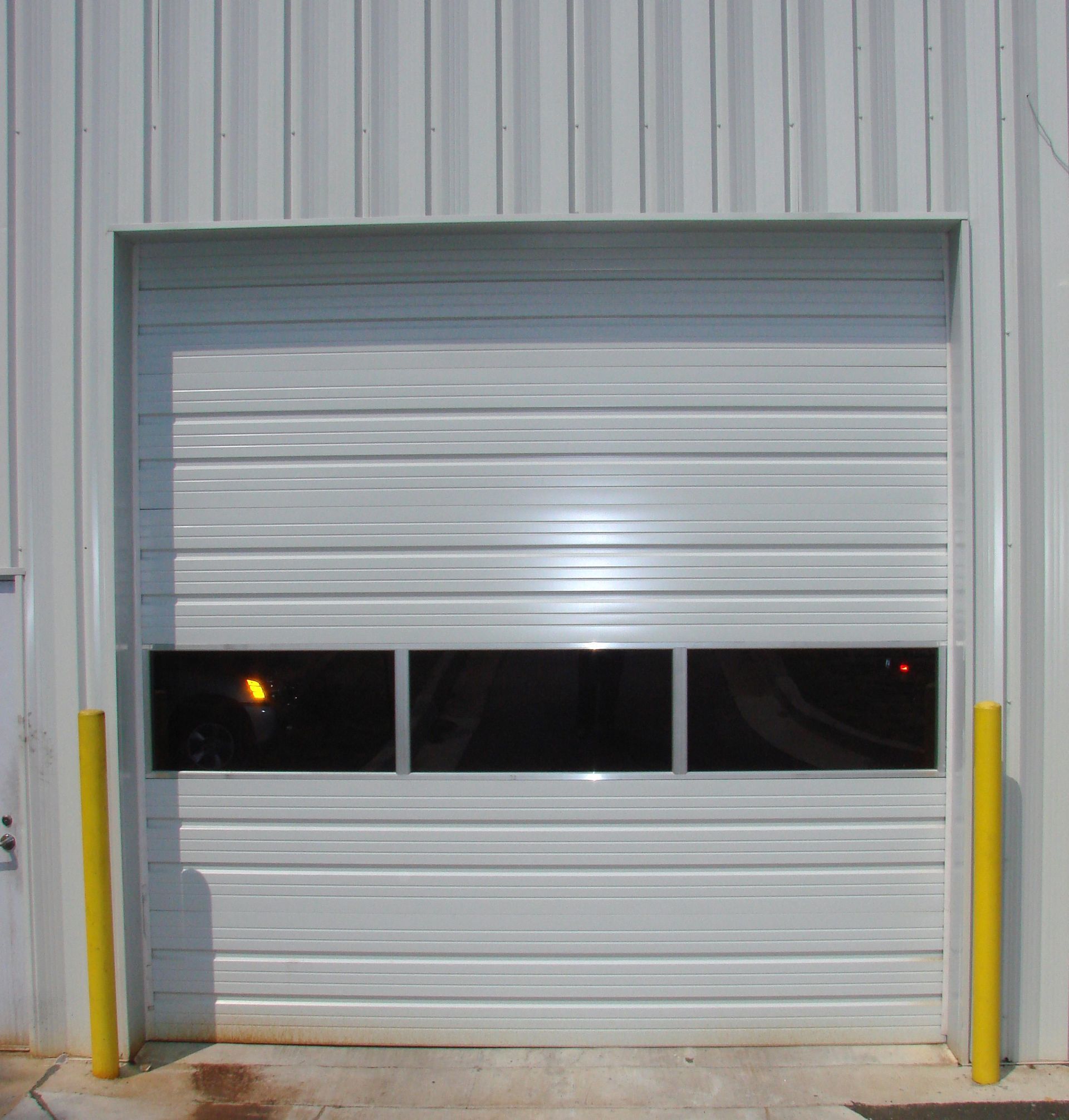 A white garage door with three windows on it