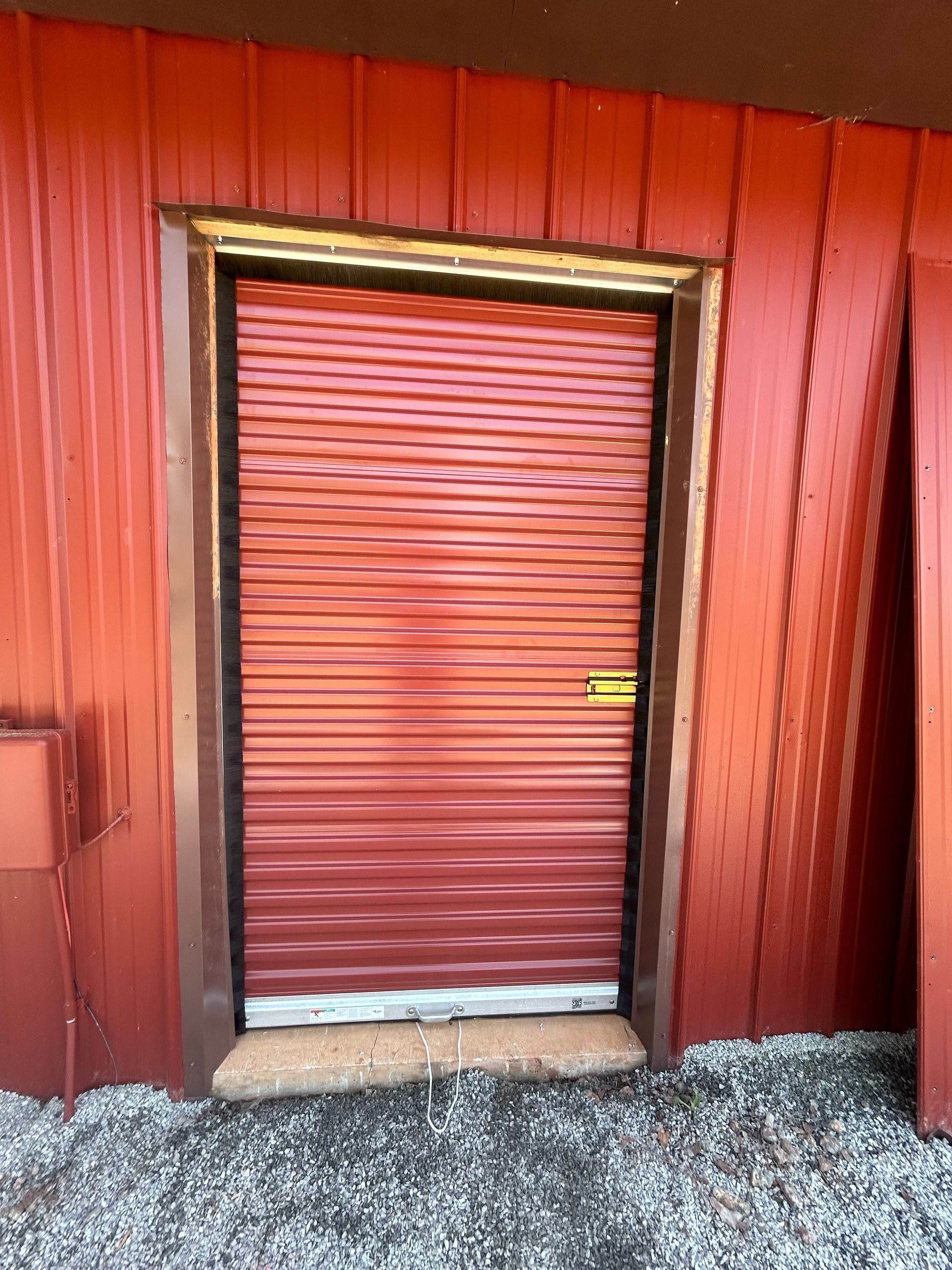 A red door with a black frame is on a red building.