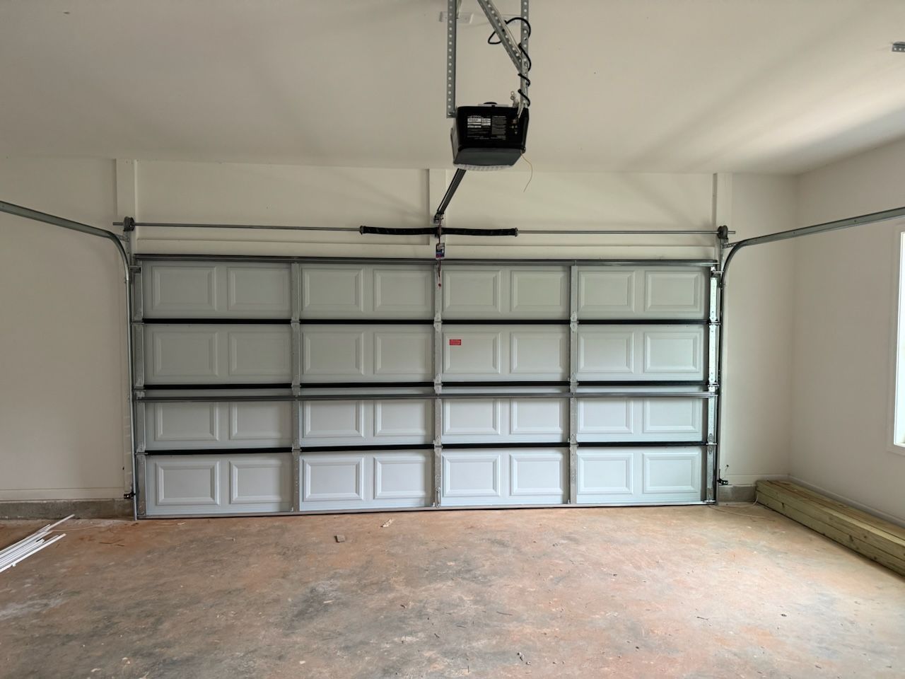An empty garage with a garage door open