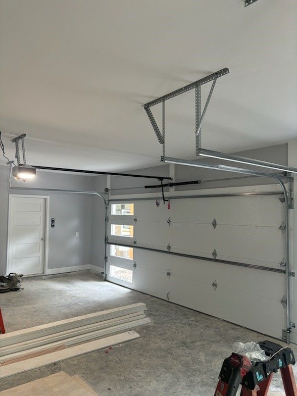 A garage with a garage door open and a ladder.