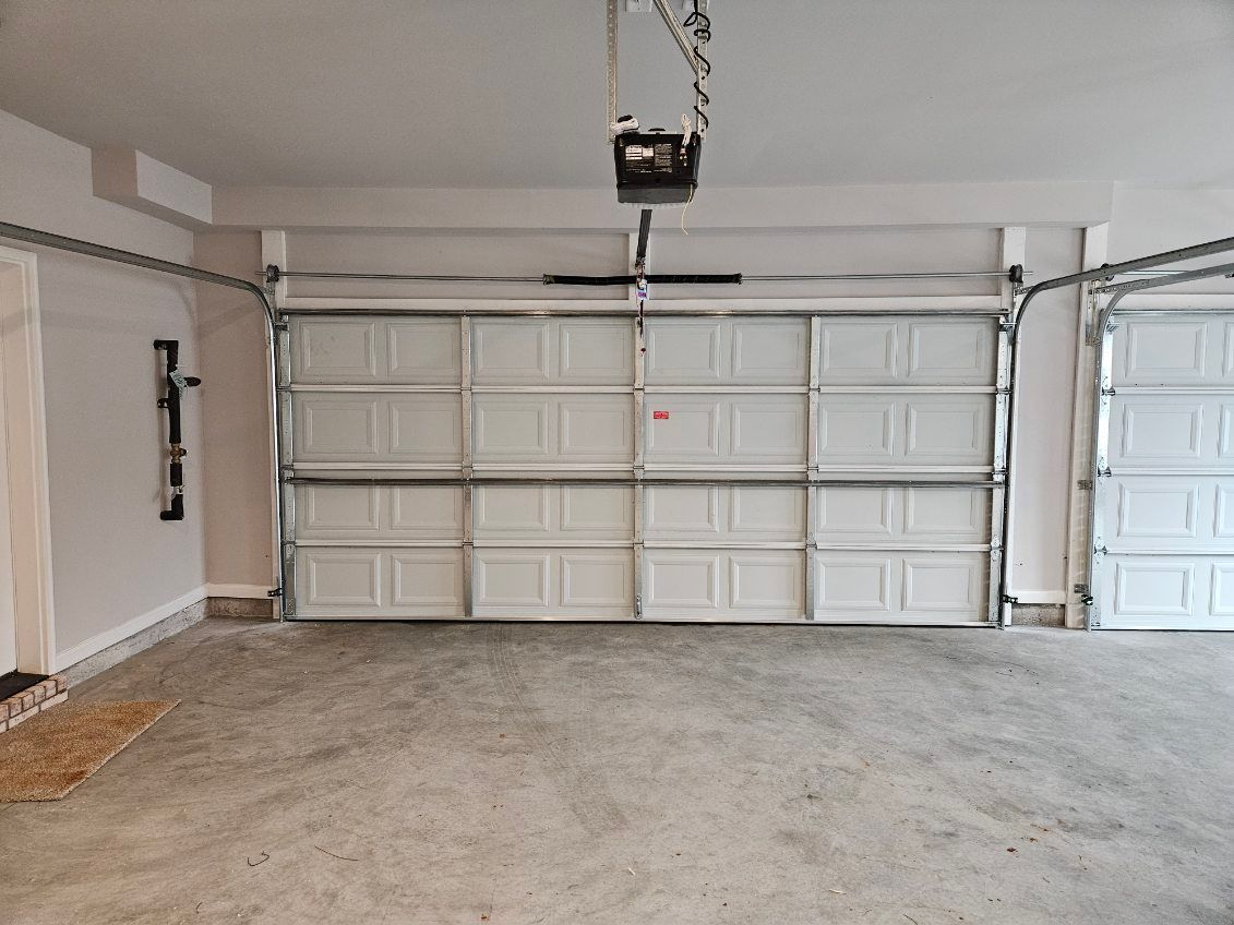 An empty garage with a large white garage door