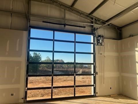 A large garage door with a view of a field.