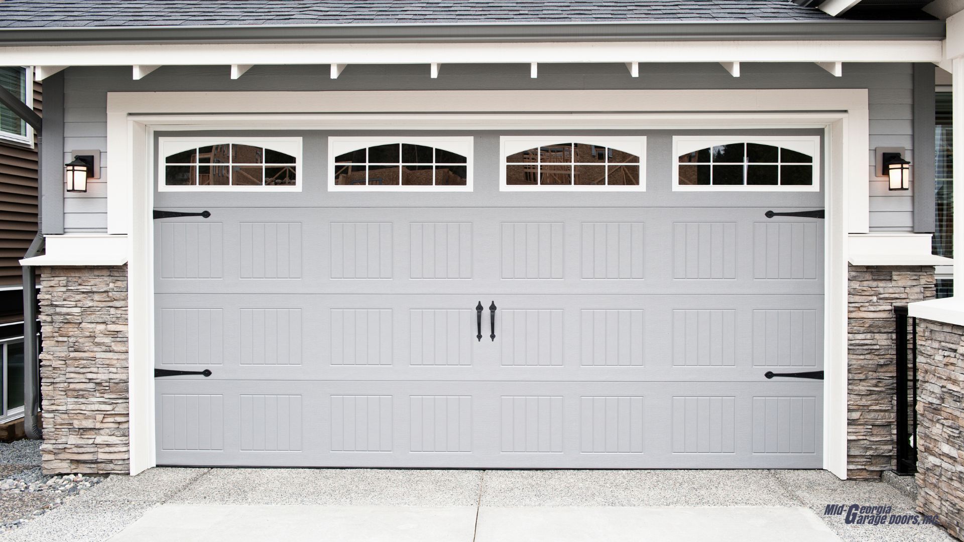 A gray garage door is sitting in front of a house in Douglasville Ga.