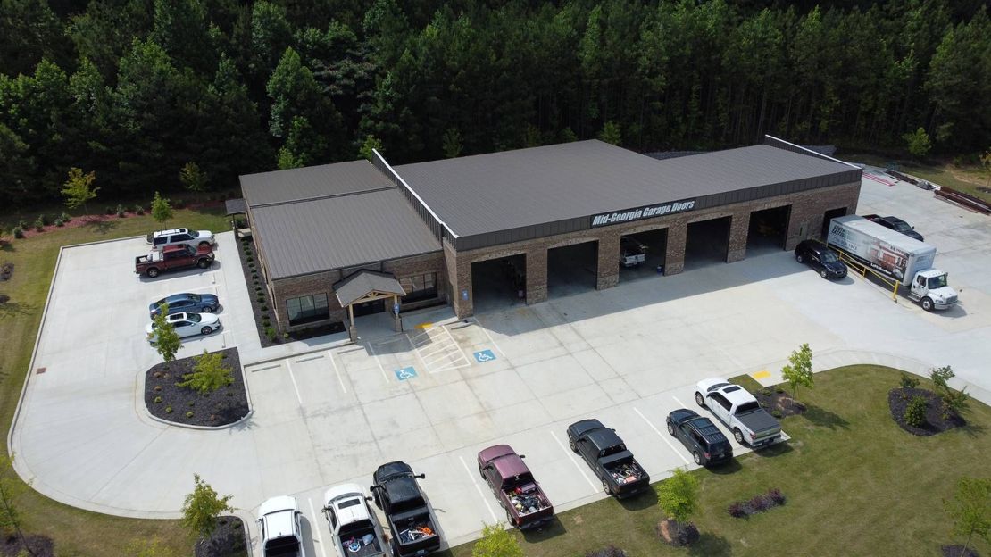 An aerial view of a large building with a lot of cars parked in front of it.