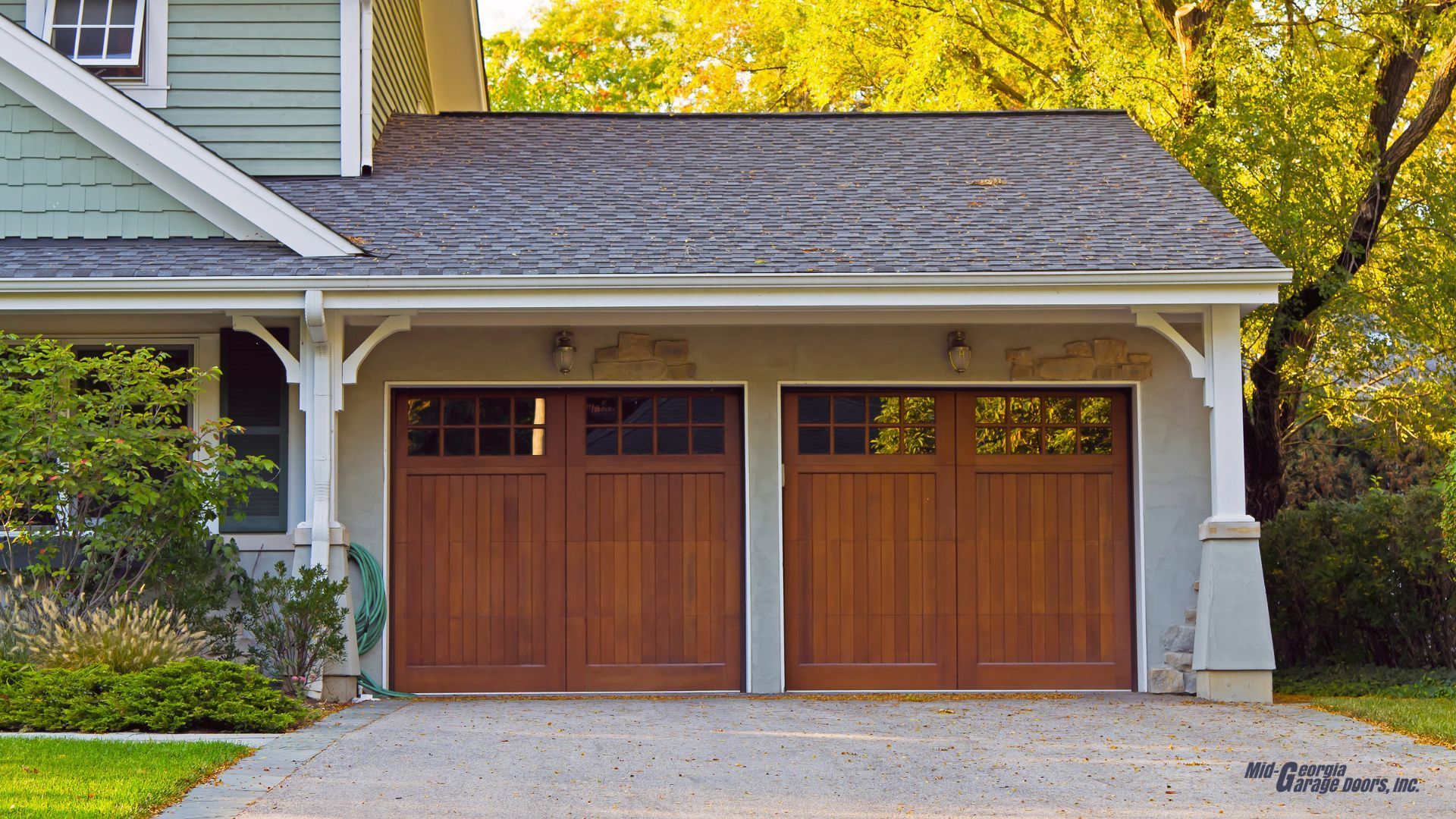 A house with two wooden garage doors and a driveway in Douglasville Ga