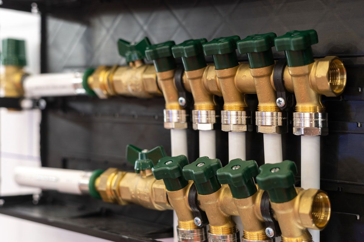 A close up of a row of brass pipes with green handles.