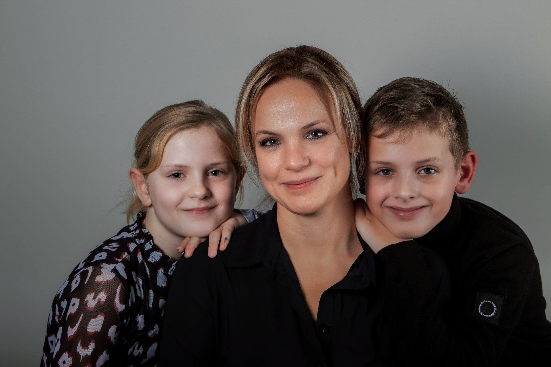 Een vrouw poseert voor een foto met twee kinderen.