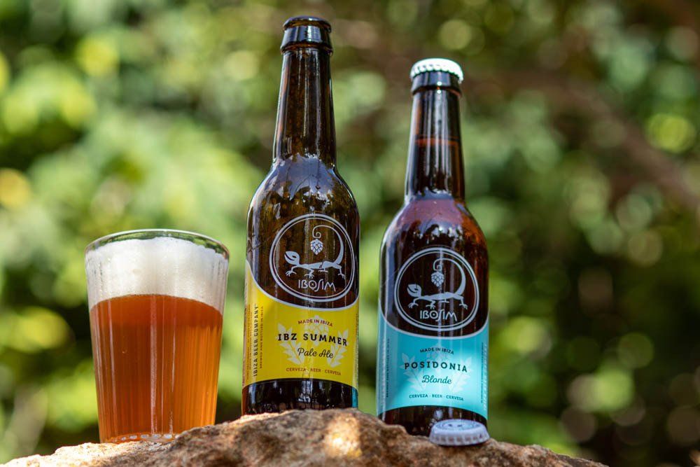 Op een rots staan ​​twee flesjes bier en een glas bier. Ibosum