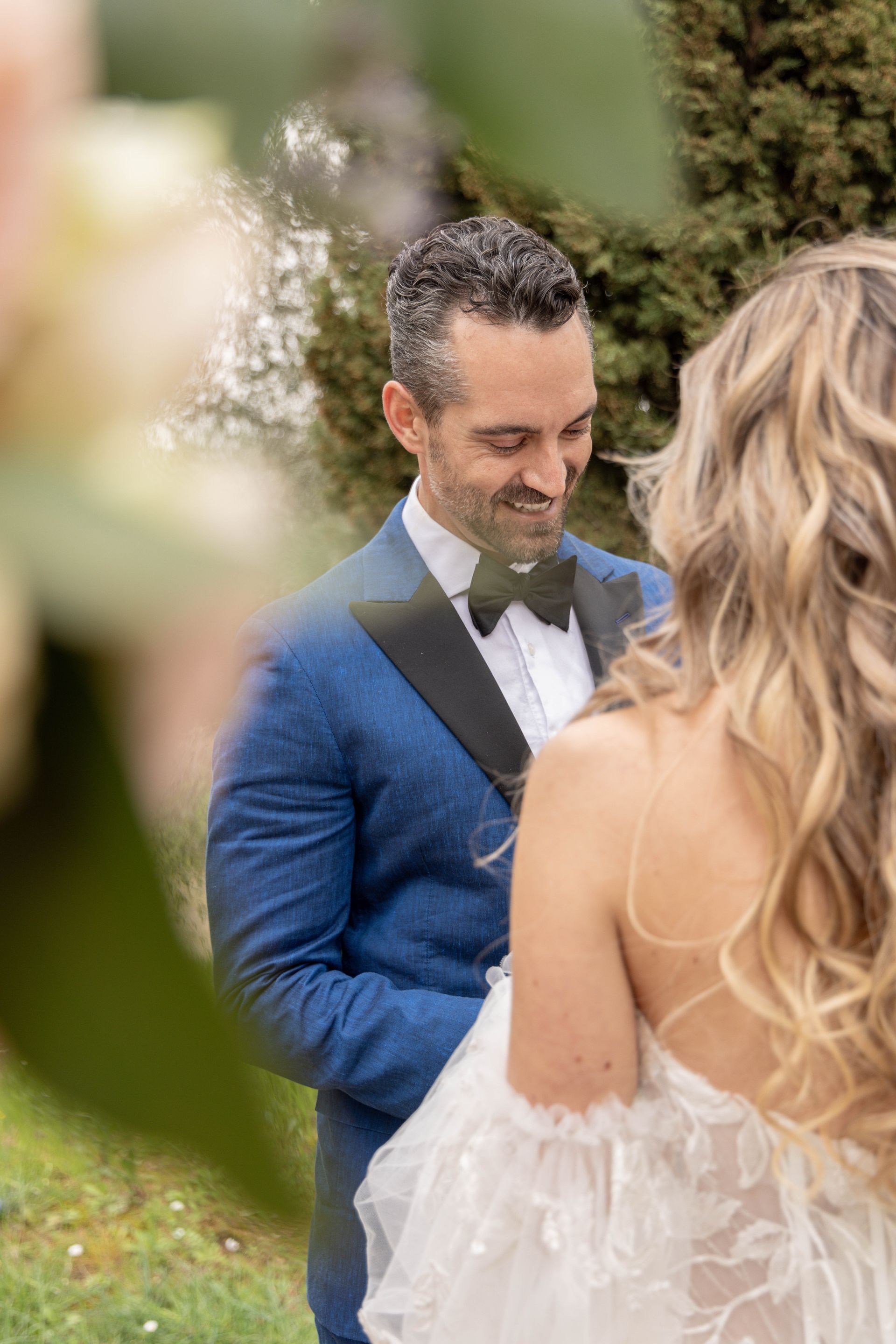 Een man en een vrouw kussen elkaar onder een witte paraplu.