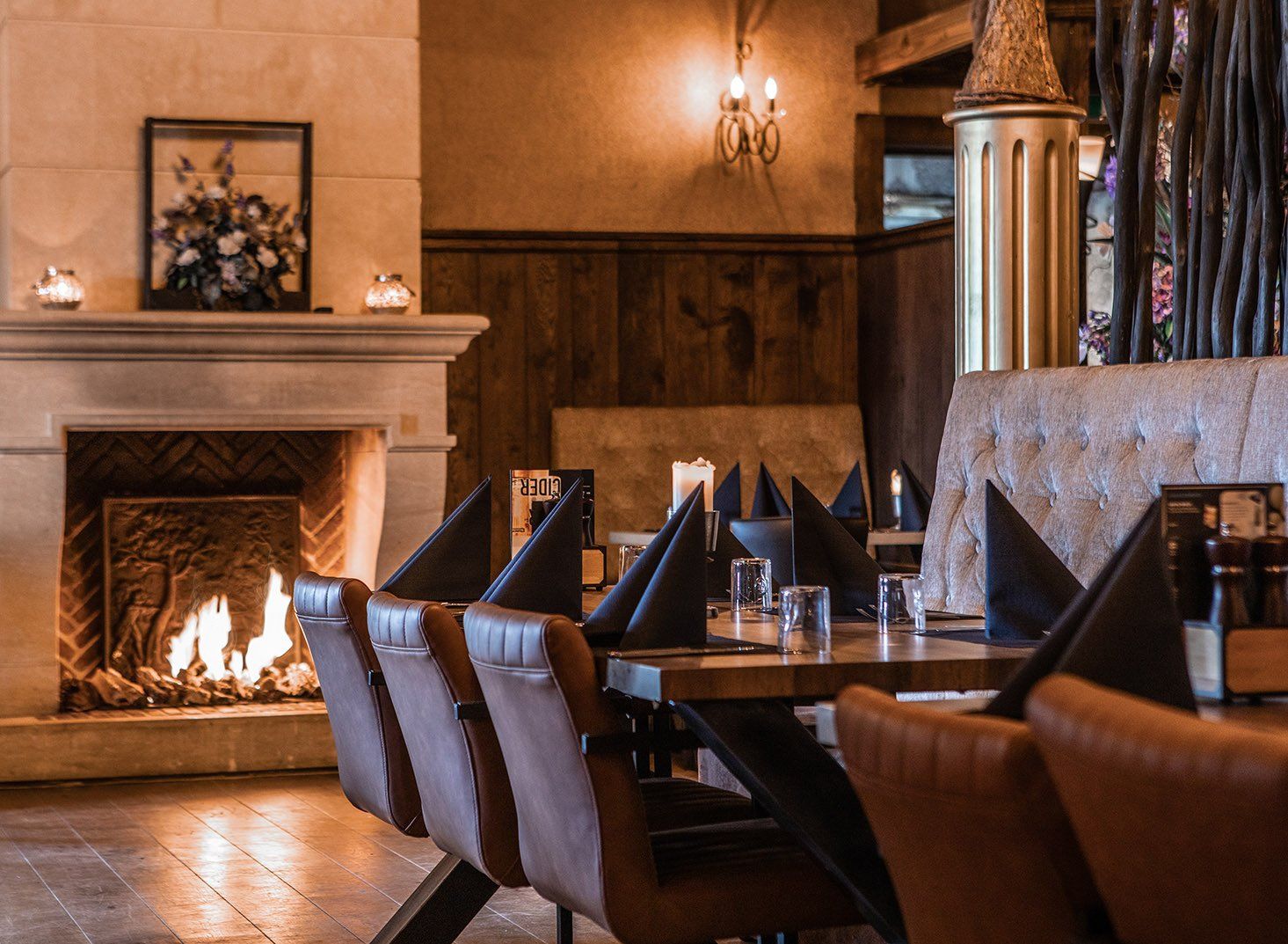 Een restaurant met tafels en stoelen en een open haard