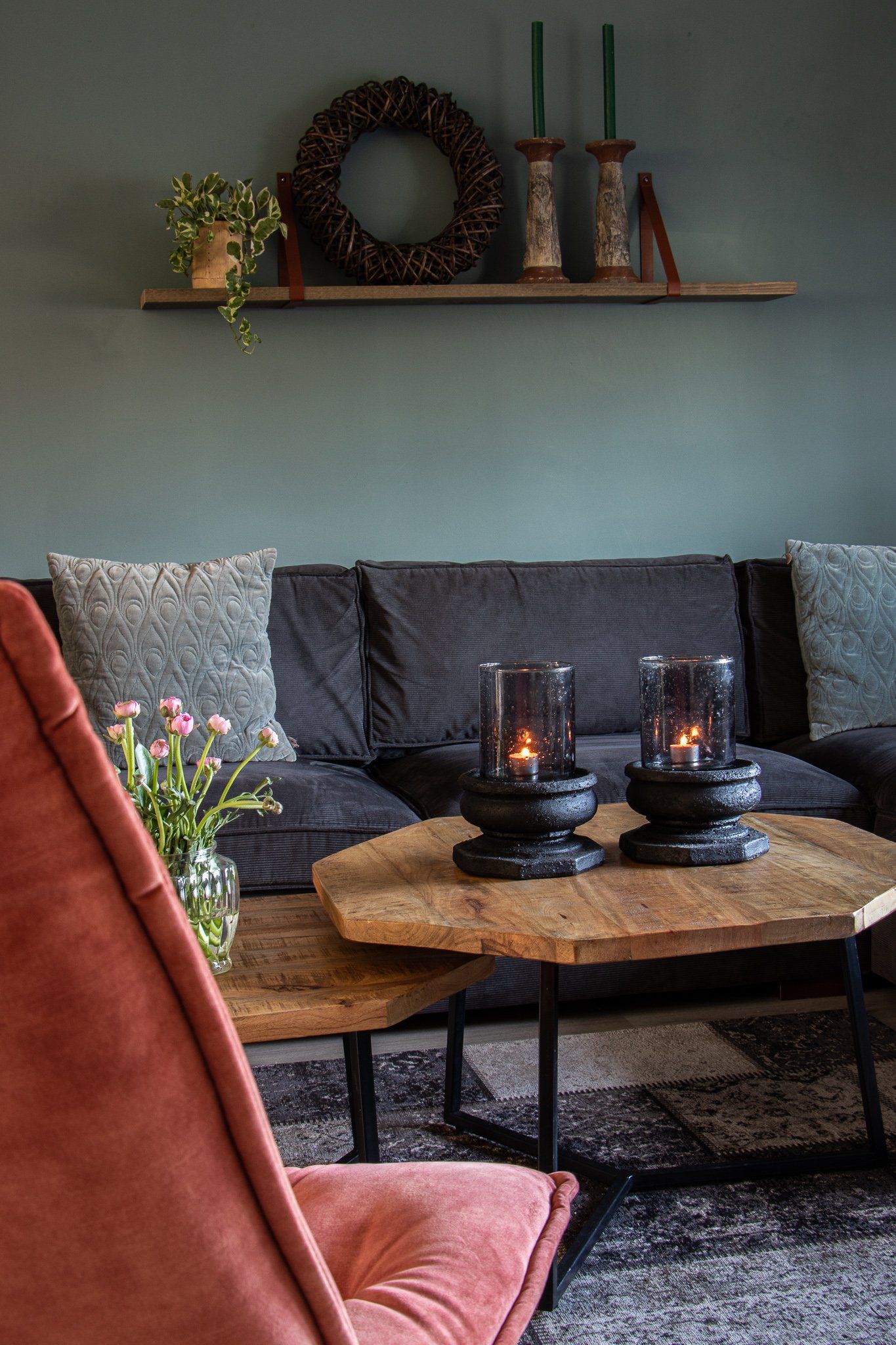 Een woonkamer met een bank en een tafel met kaarsen erop.