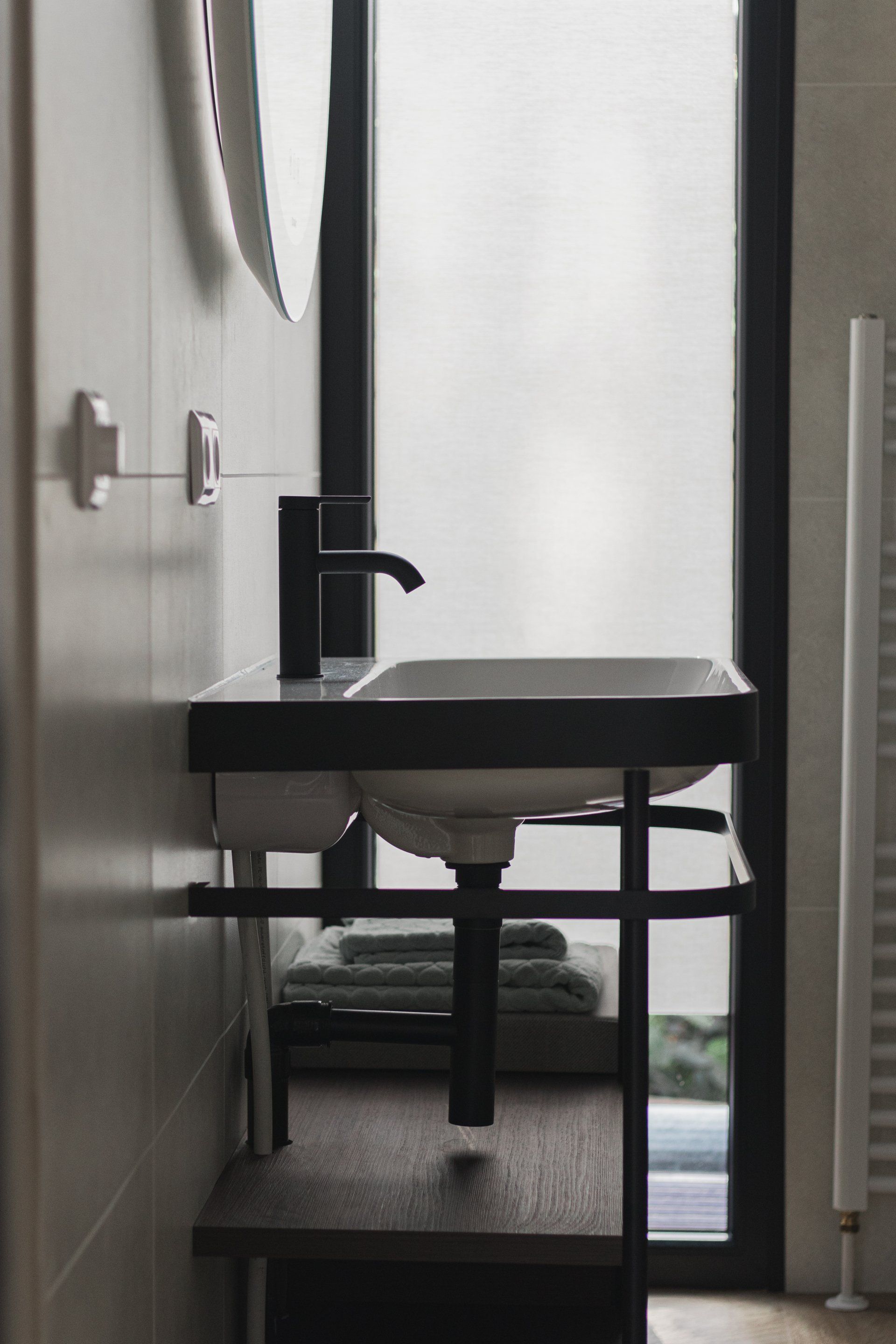 Een badkamer met een wastafel en een raam