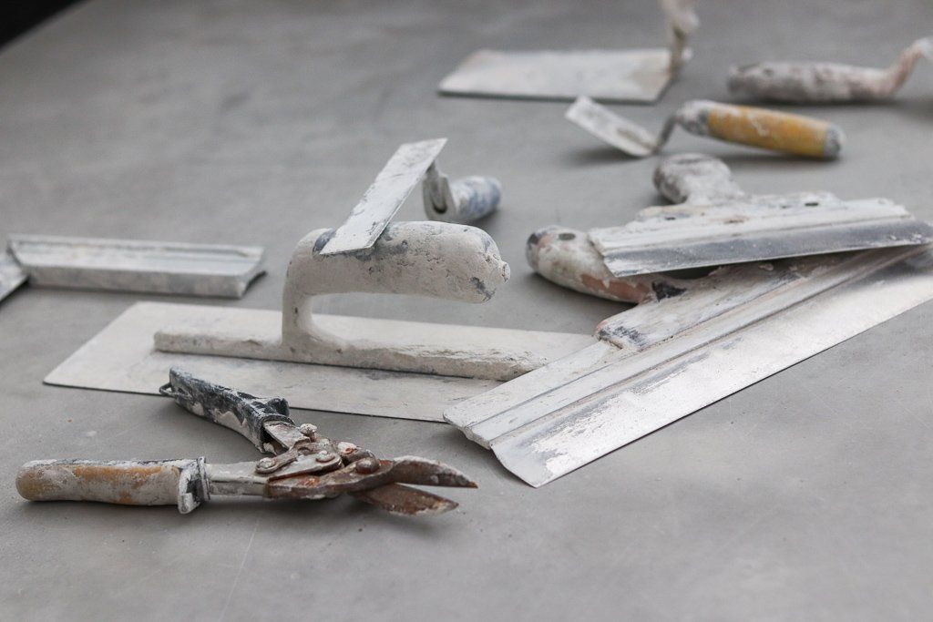 Er ligt een heleboel gereedschap op de grond. Stuc werk