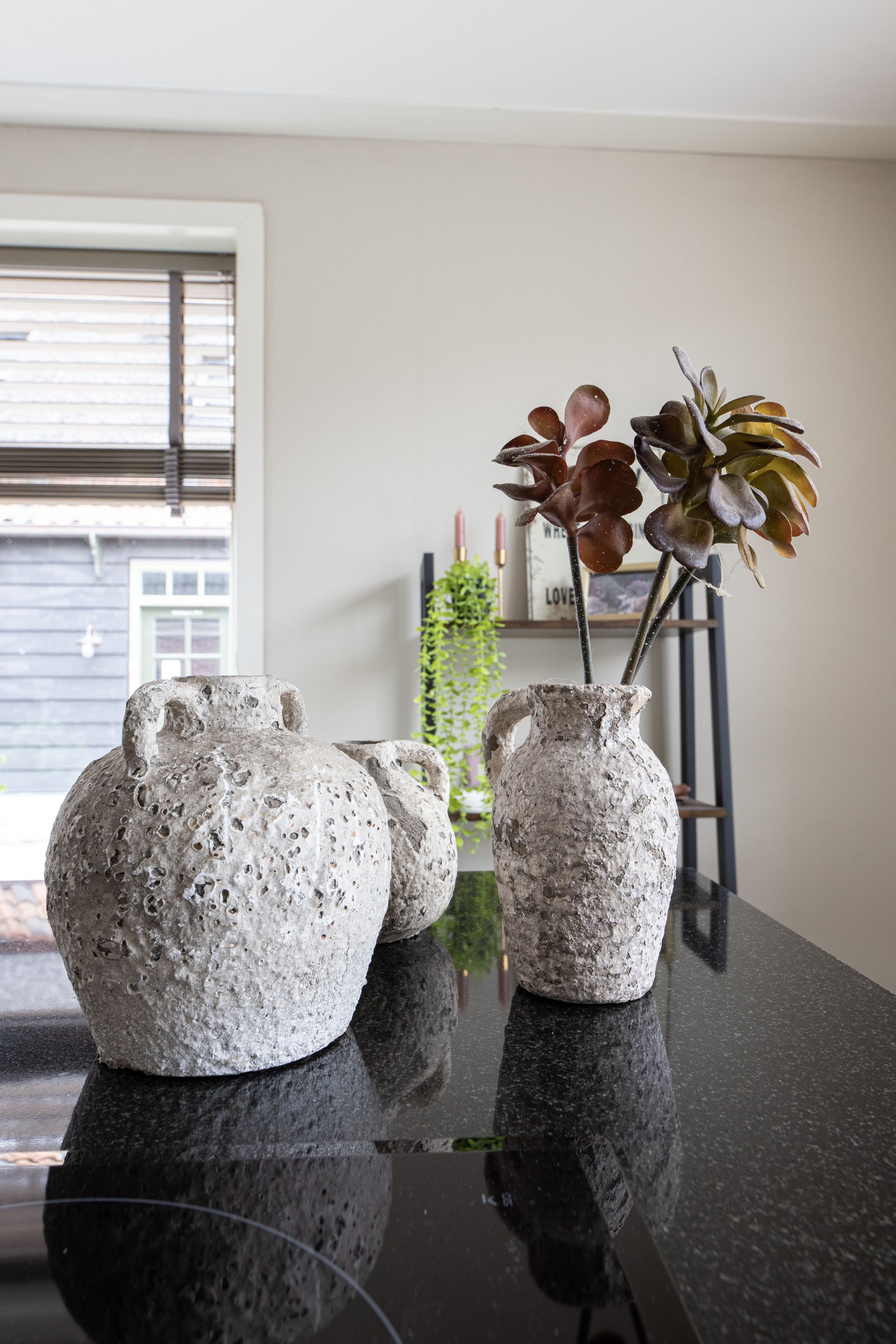 Op een zwarte toonbank staan ​​drie vazen.