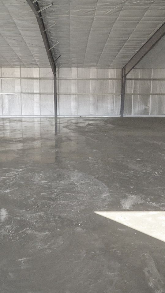 Empty insulated warehouse interior with concrete floor and metal-framed walls