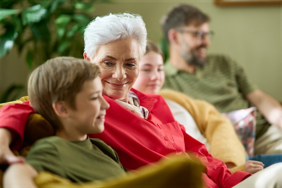 Una familia está sentada en un sofá viendo la televisión juntos.