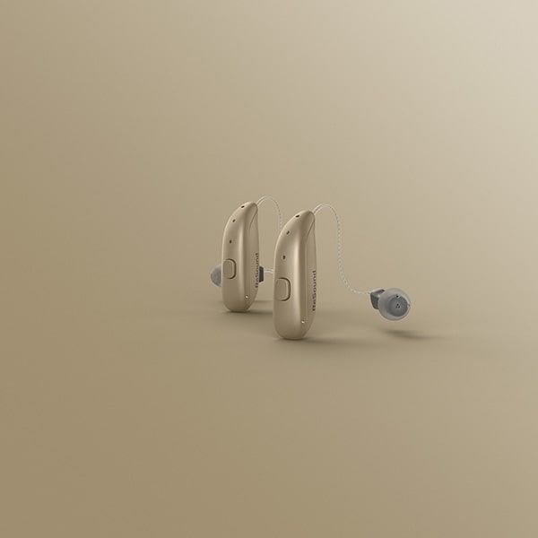 Un par de audífonos colocados uno al lado del otro sobre una superficie beige.