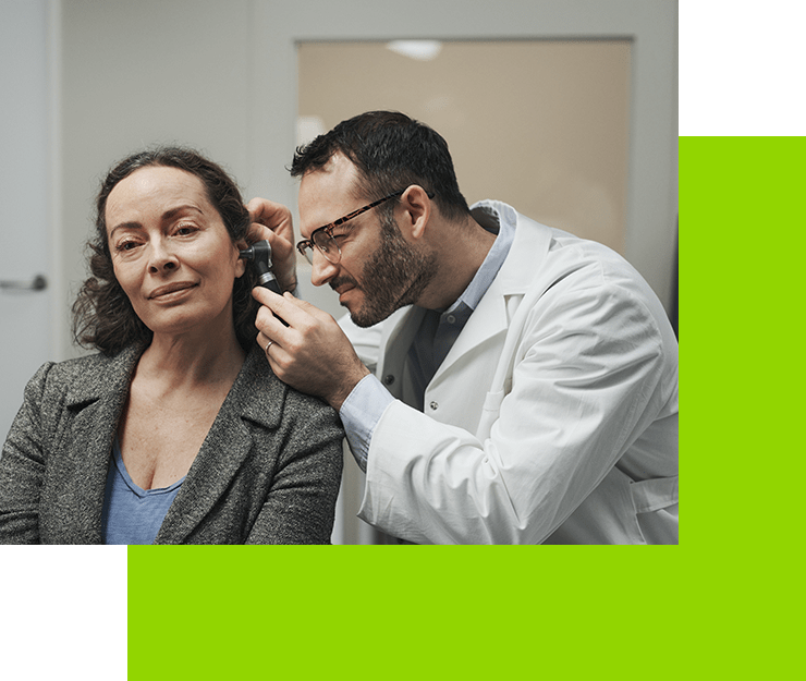 Un médico está examinando la oreja de una mujer con un estetoscopio.