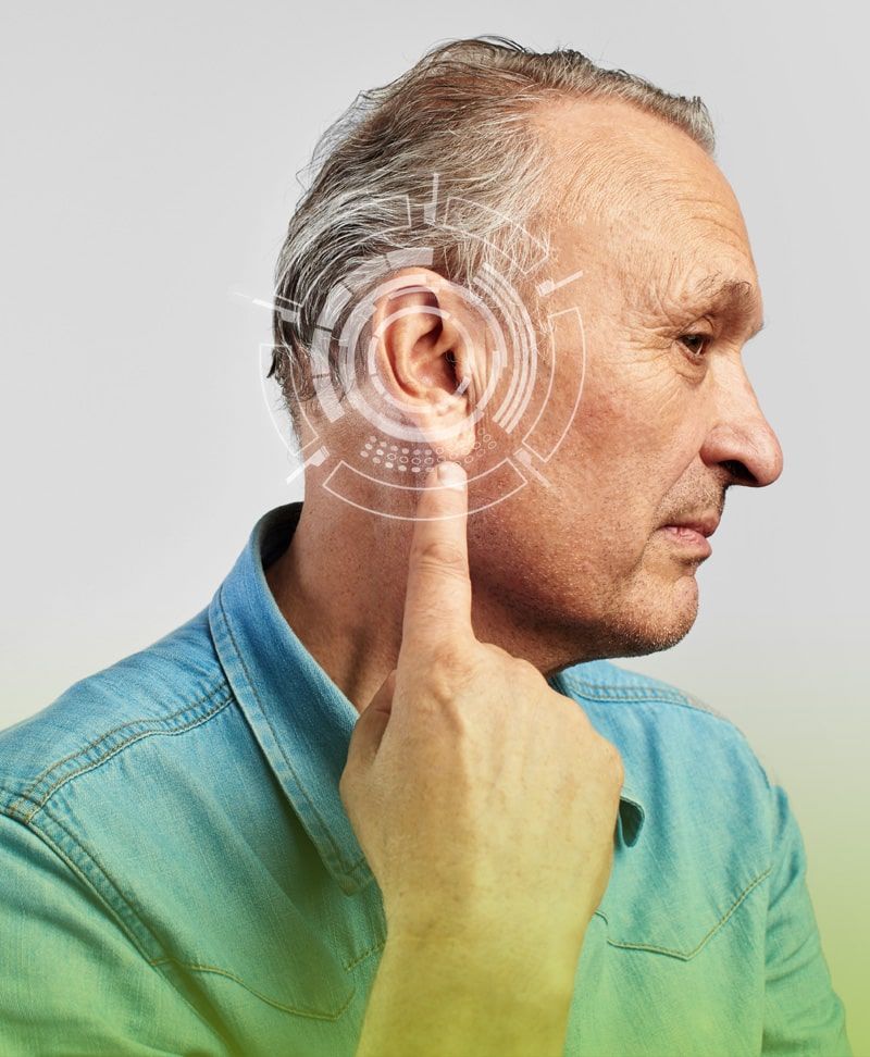 Un hombre se toca la oreja con el dedo.