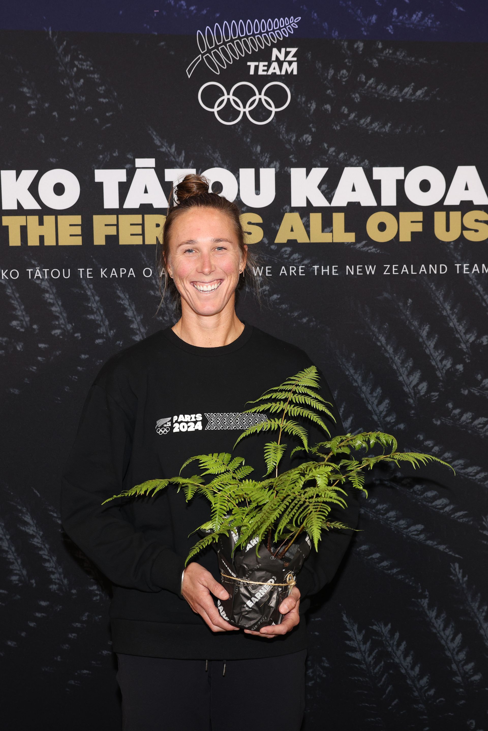 Emma Twigg holding fern as ambassador for New Zealand Olympics