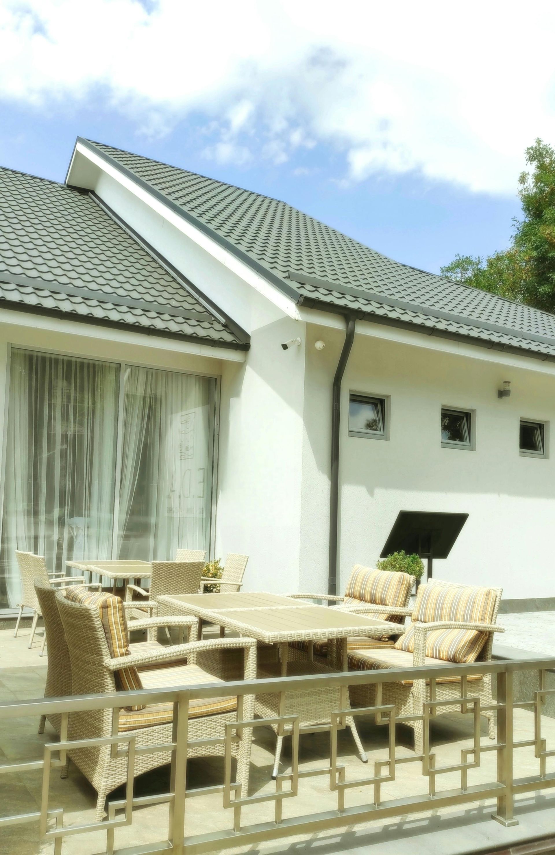 A white house with a roof that has shingles on it