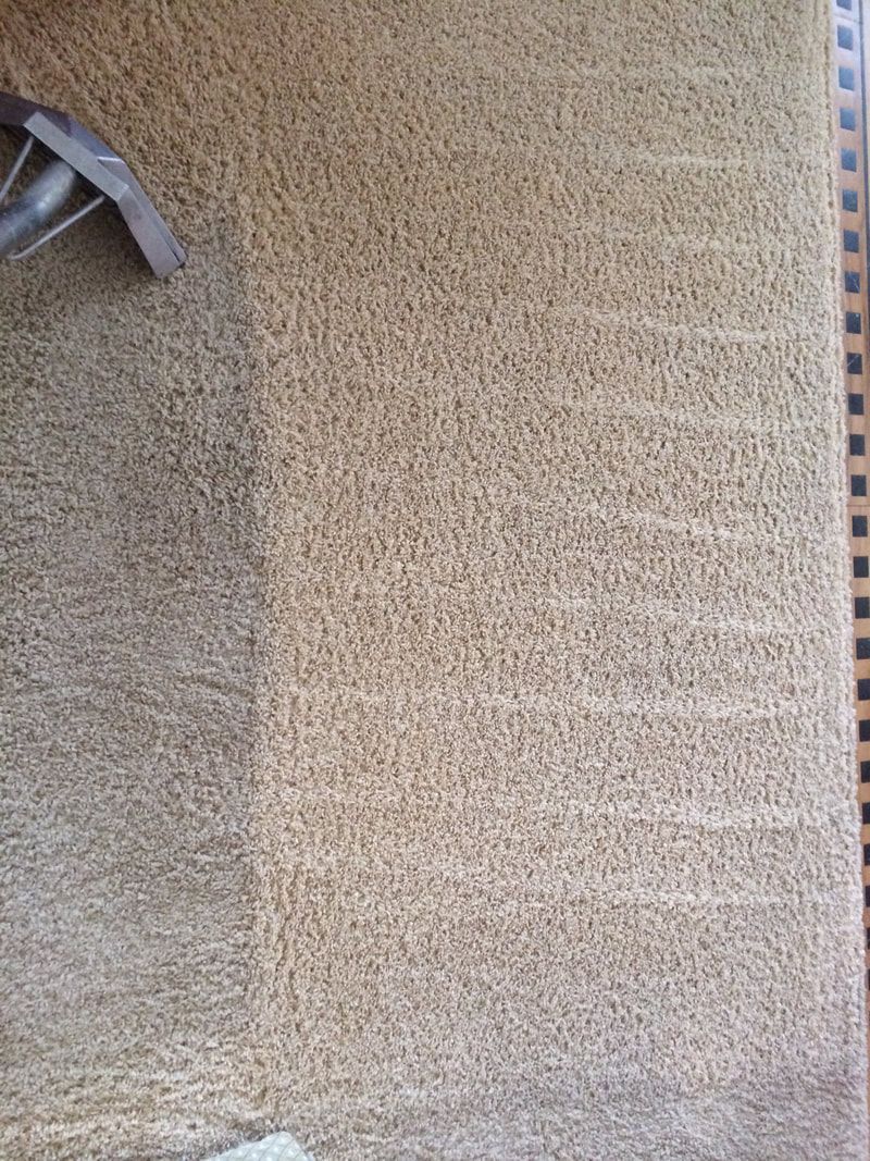 A close up of a carpet on a wall with a chair in the background.