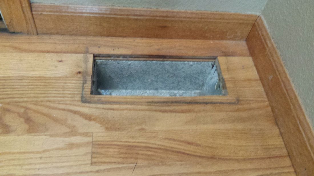 A wooden floor with a hole in the middle of it.