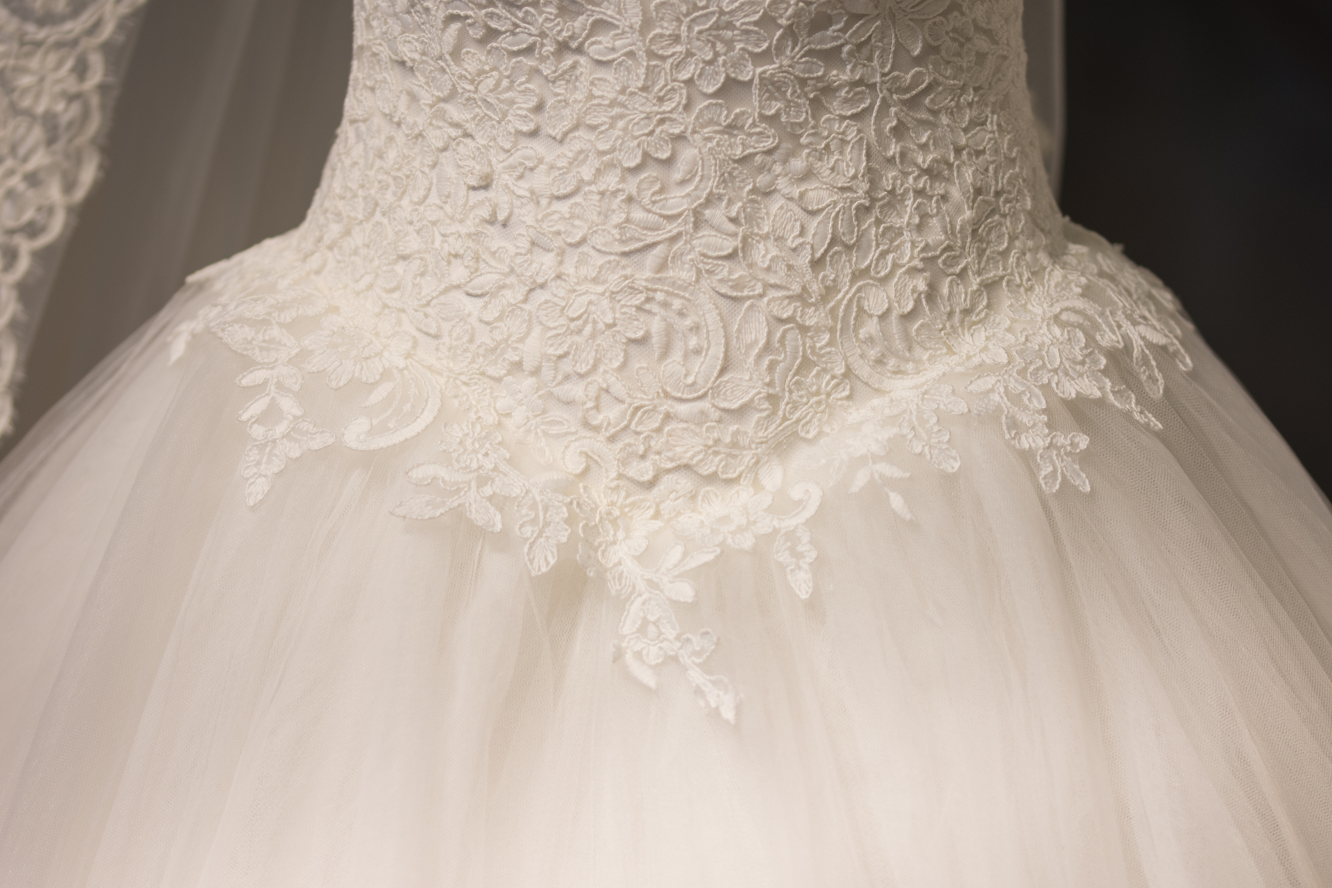 Lace bodice of a white tulle wedding dress with floral embroidery