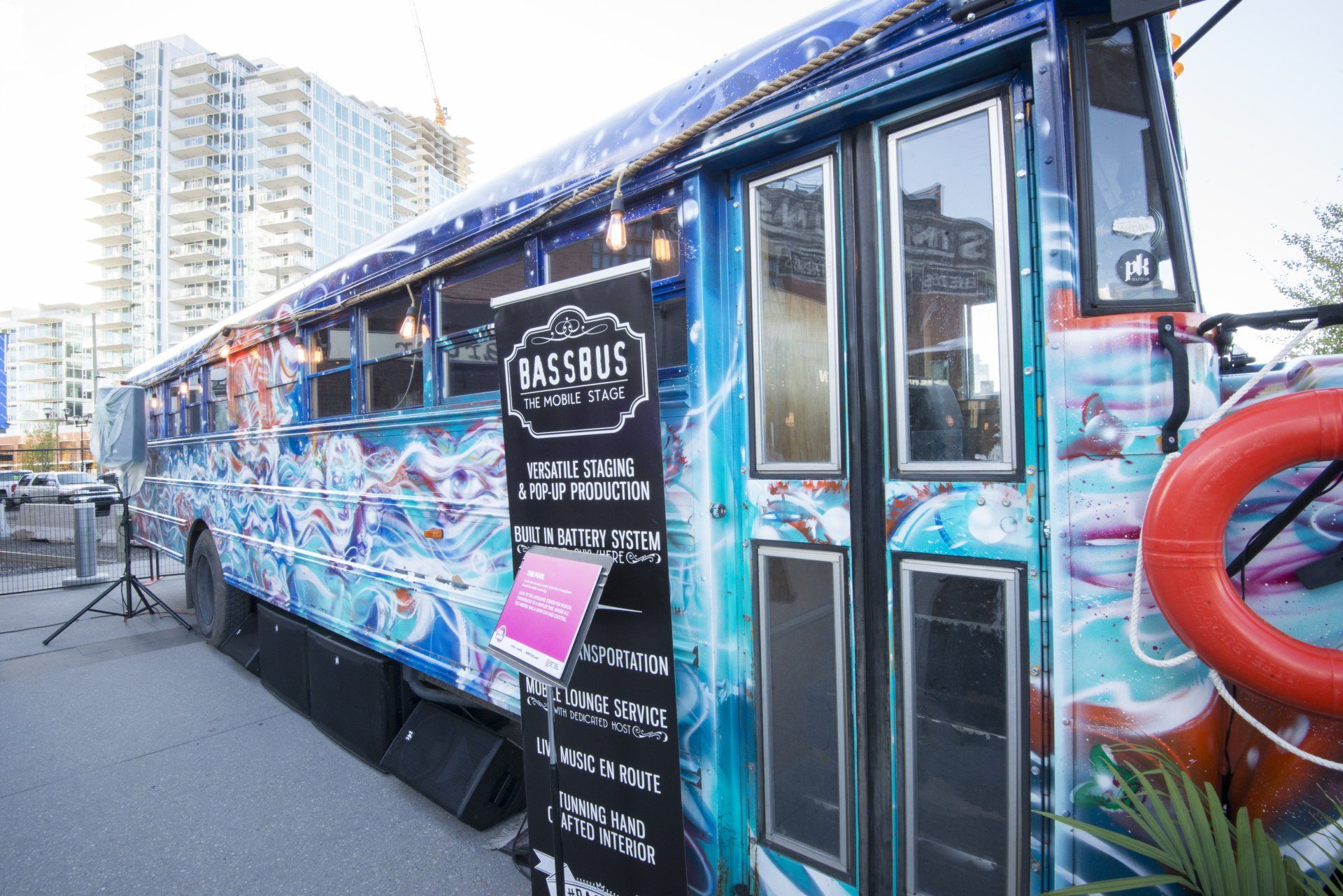 A blue bus with graffiti on the side is parked in front of a building.