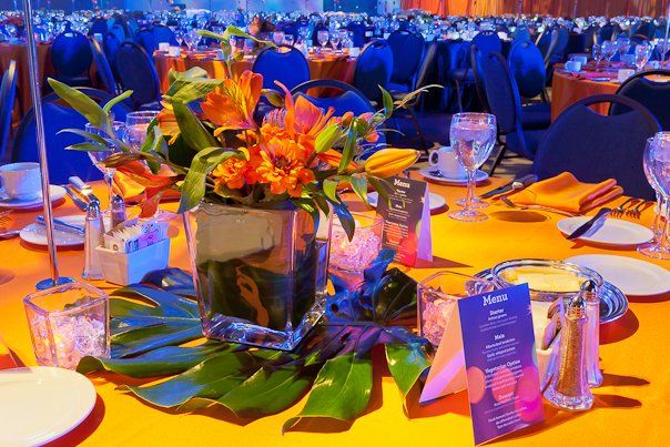 A table set for a dinner party with a vase of flowers on it.