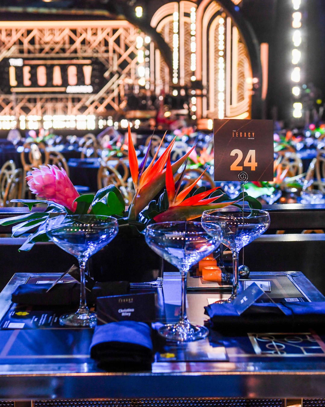 A table with two martini glasses and a sign that says legacy on it