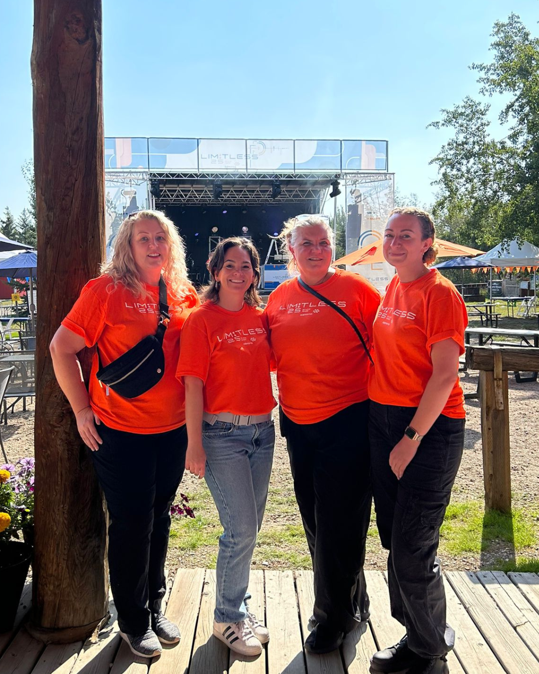 A group of women wearing orange shirts are posing for a picture.