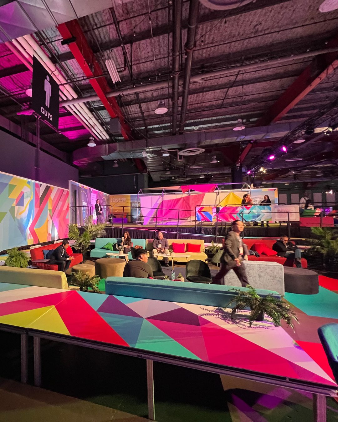 A group of people are sitting at tables in a large room.