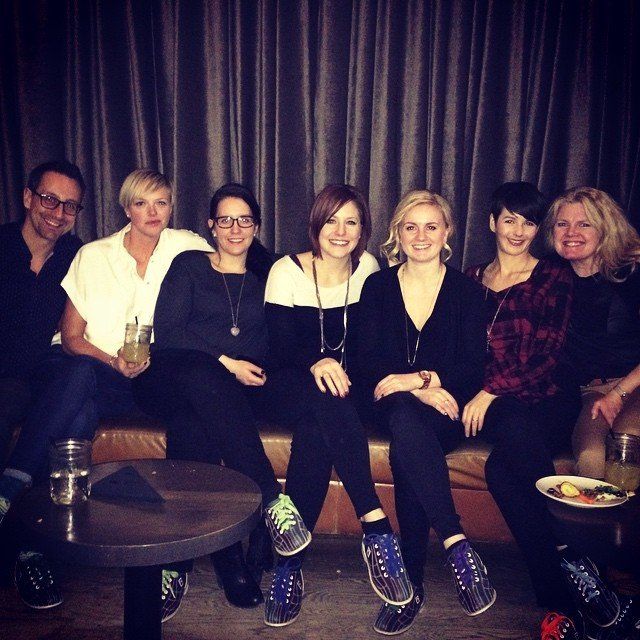 A group of people are posing for a picture while sitting on a couch