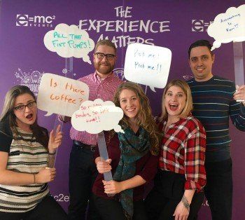 A group of people standing in front of a wall that says the experience matters