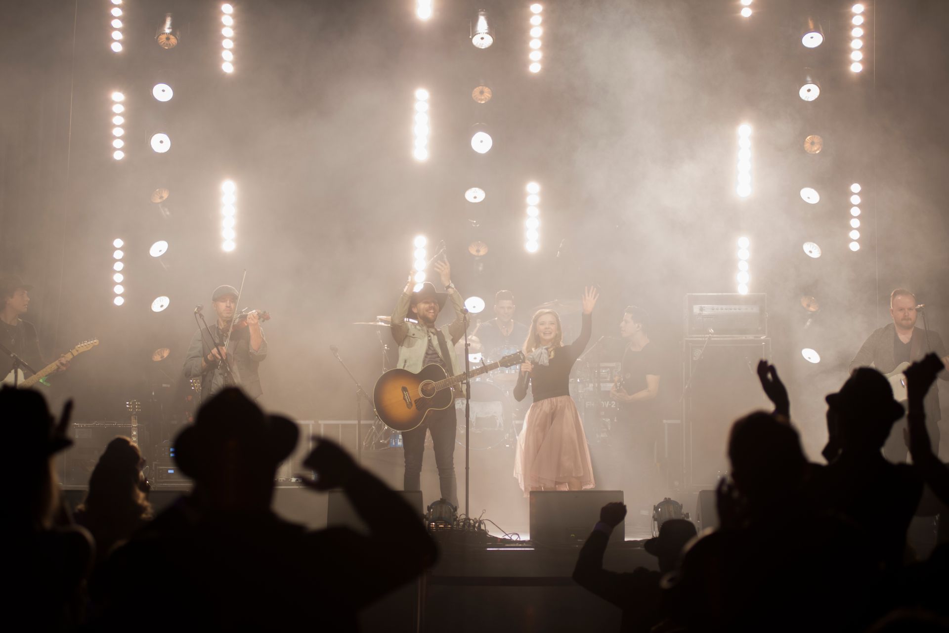 A group of people are standing on a stage in front of a crowd.