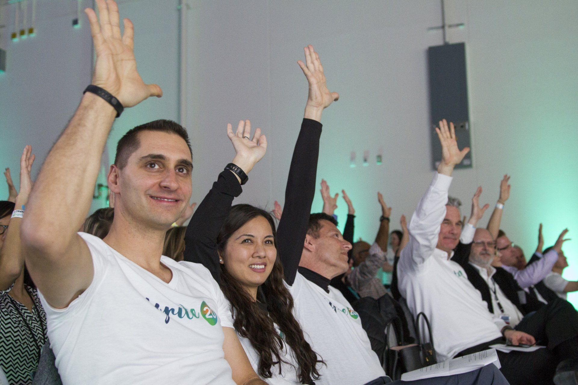 A group of people are raising their hands in the air.