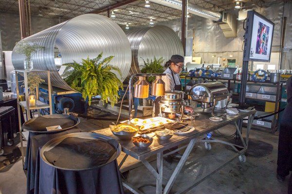 A man is preparing food at a table in a factory.