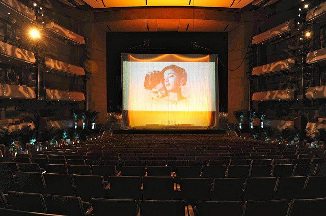 An empty auditorium with a large screen on the stage.