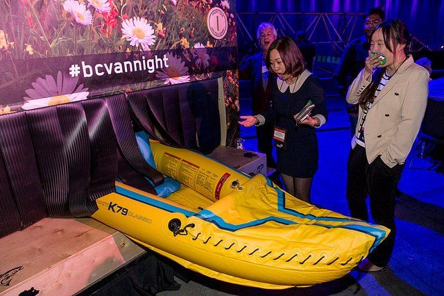 A group of people are standing around a yellow inflatable boat.