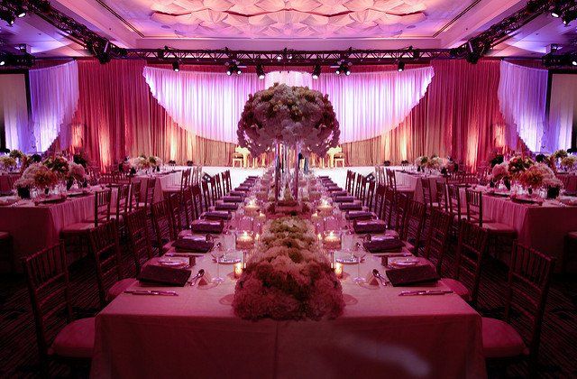 A large room with tables and chairs set up for a wedding reception.
