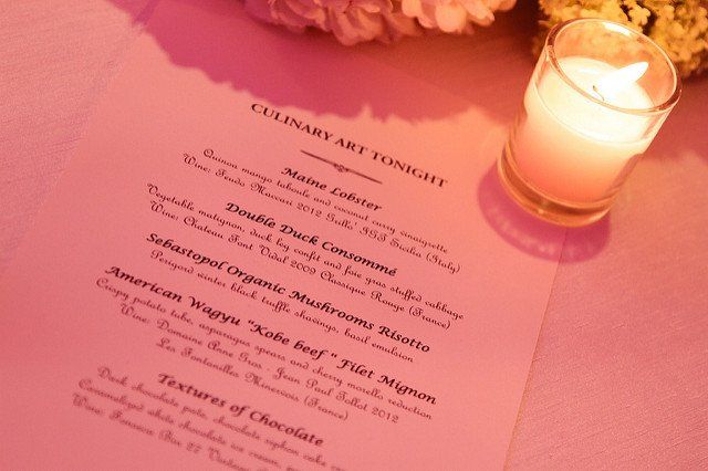 A candle sits next to a menu that says culinary art tonight