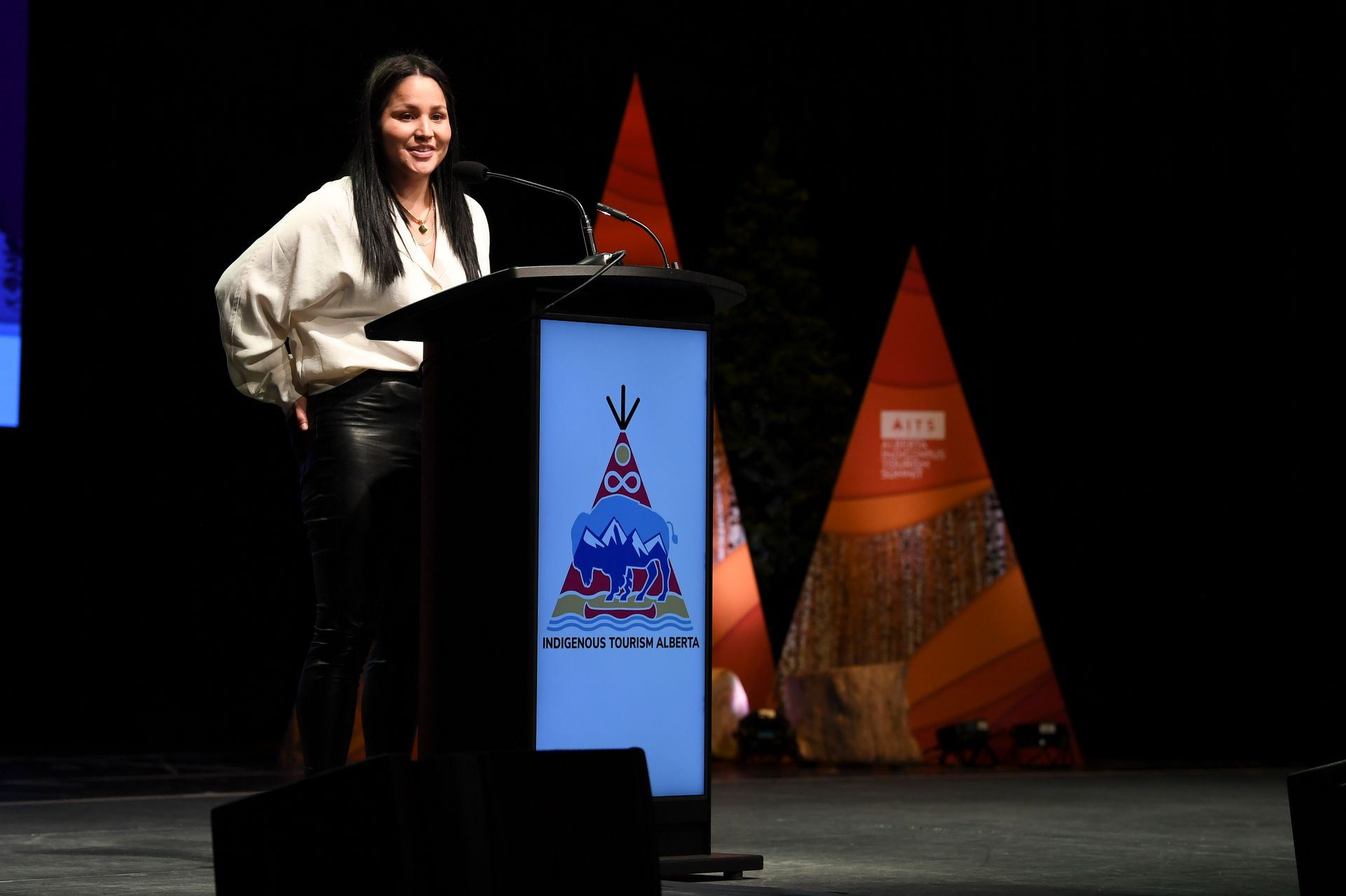 A woman is standing at a podium giving a speech.