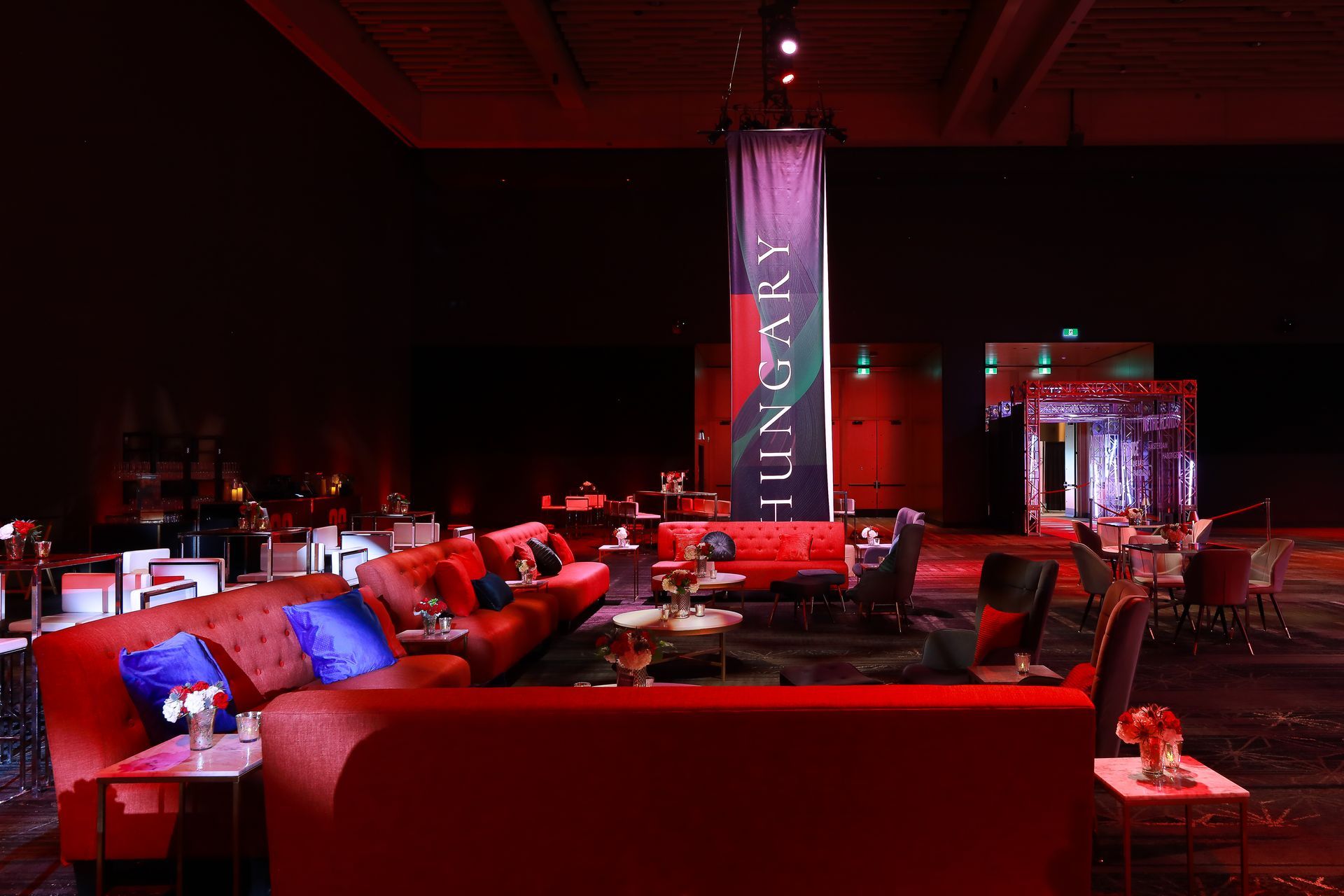 Red lounge area with couches, small tables, and a banner reading 