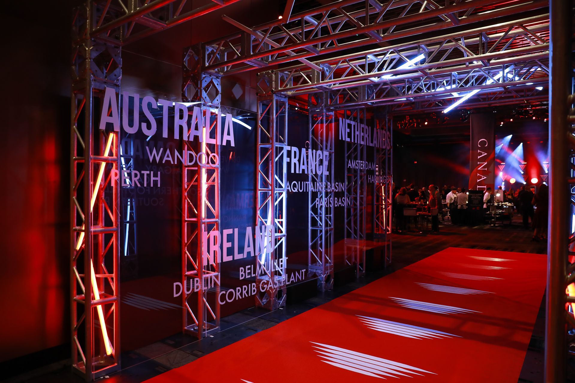 Red carpet entrance with country names on illuminated structures.