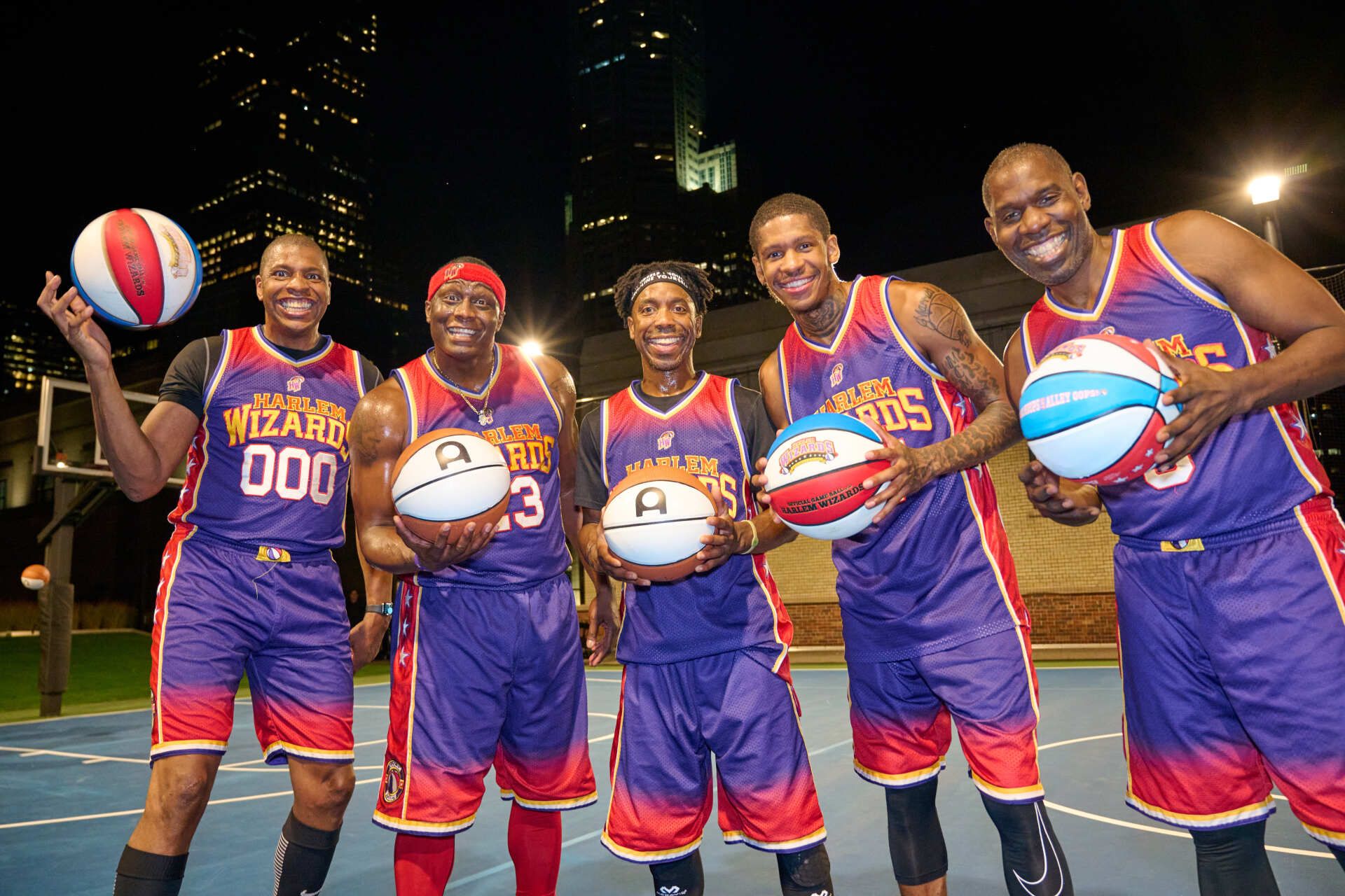 A group of basketball players are posing for a picture on a court