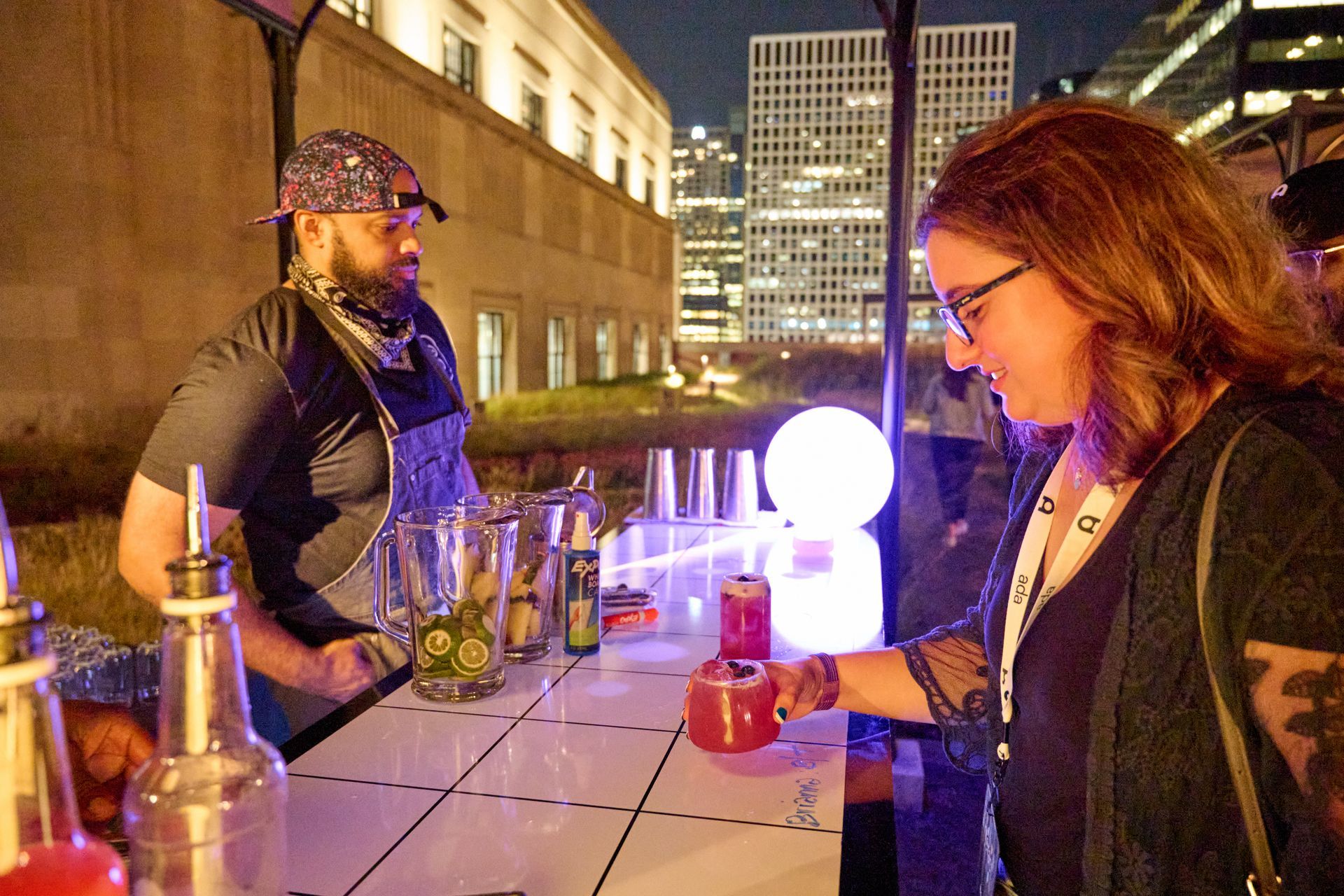 A man is serving a drink to a woman at a bar.