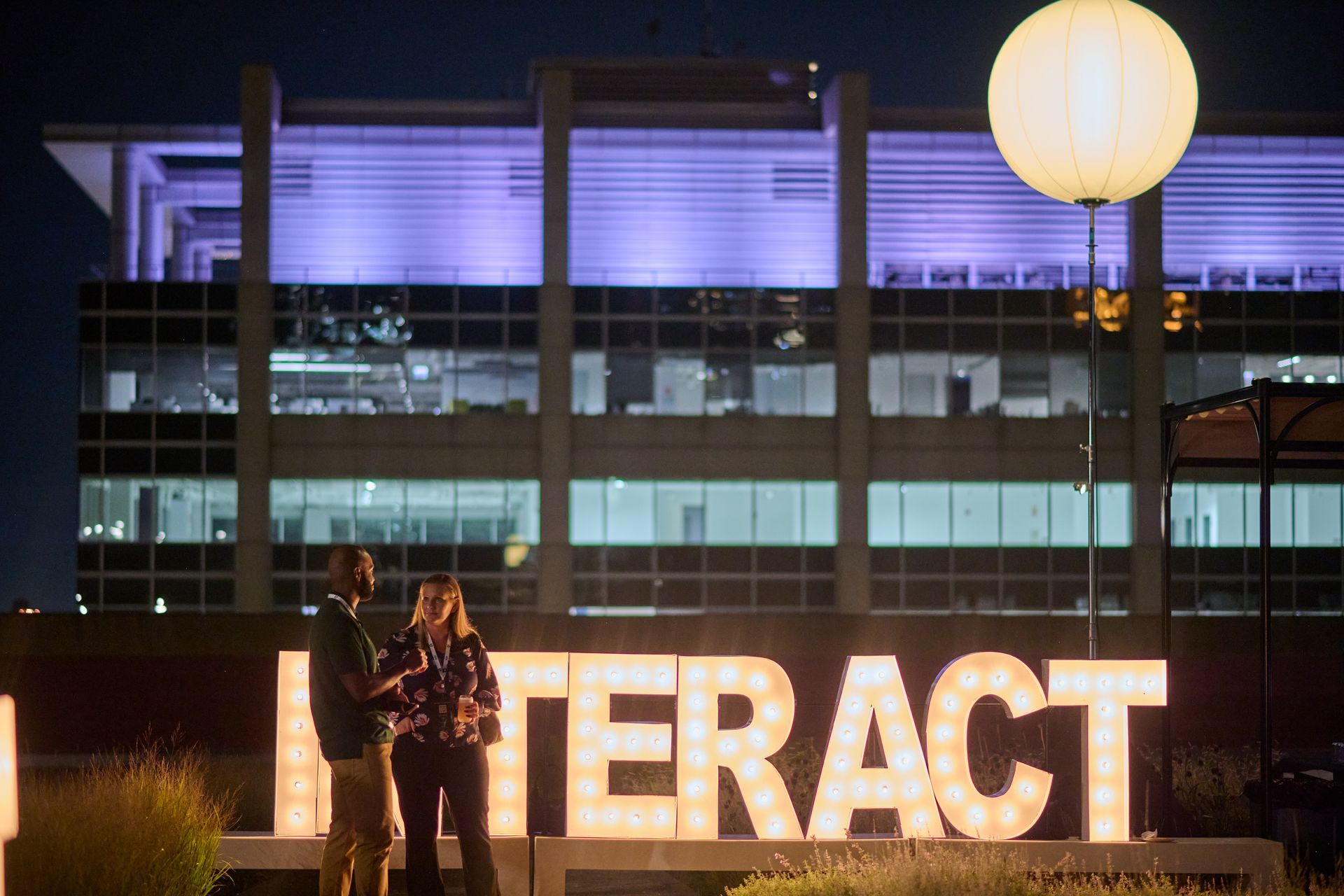 A man and a woman are standing in front of a sign that says literacy.