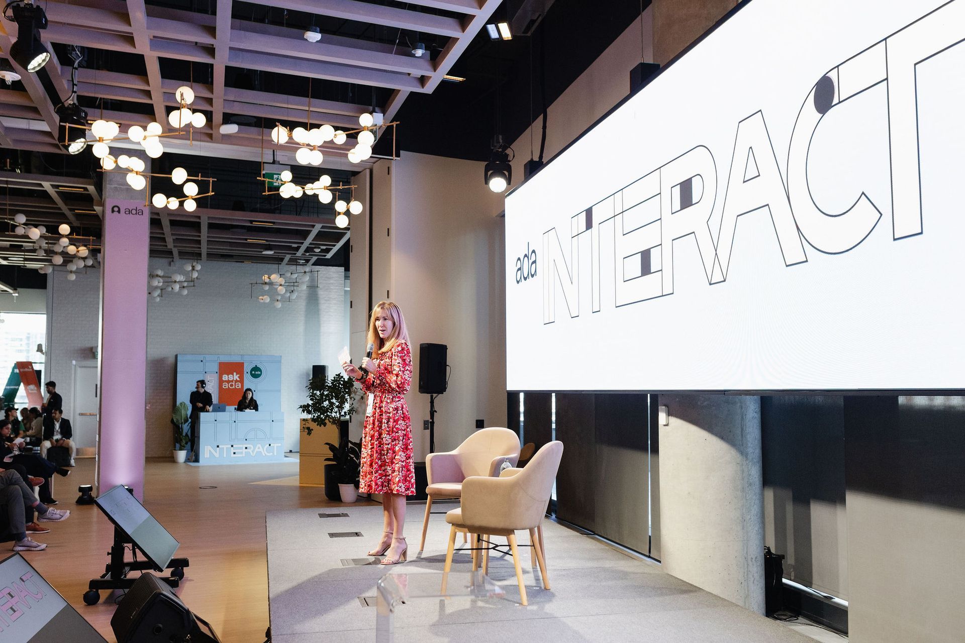 Woman in red dress speaking at a conference, 