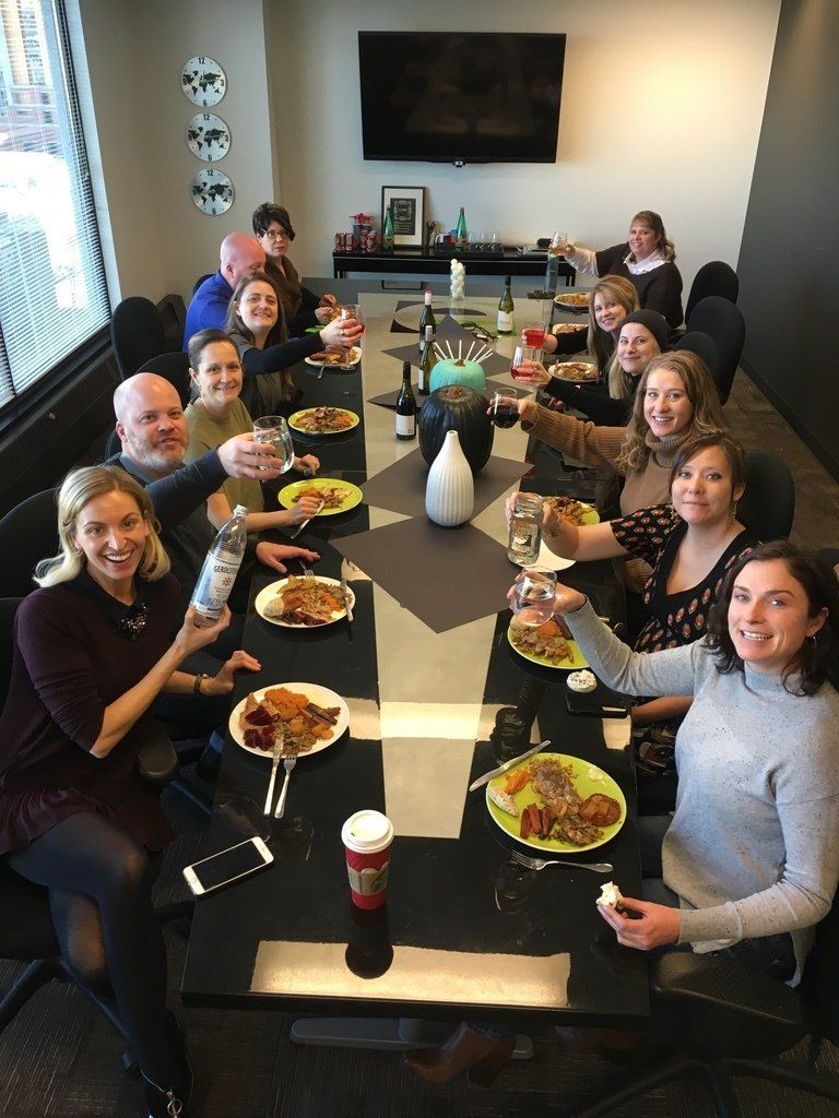 A group of people are sitting around a table with plates of food.